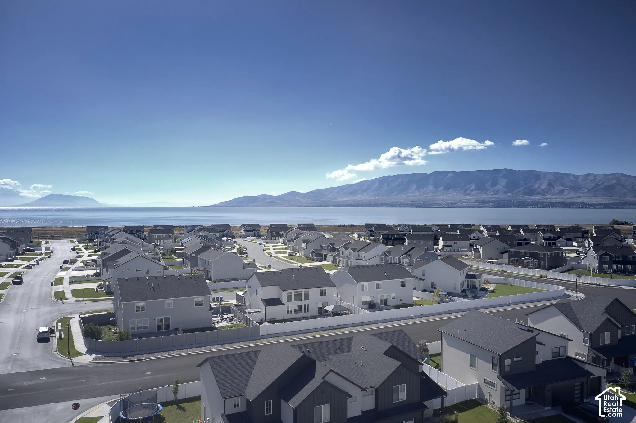Aerial perspective of residential neighborhood featuring expansive water scenery and distant mountain ranges