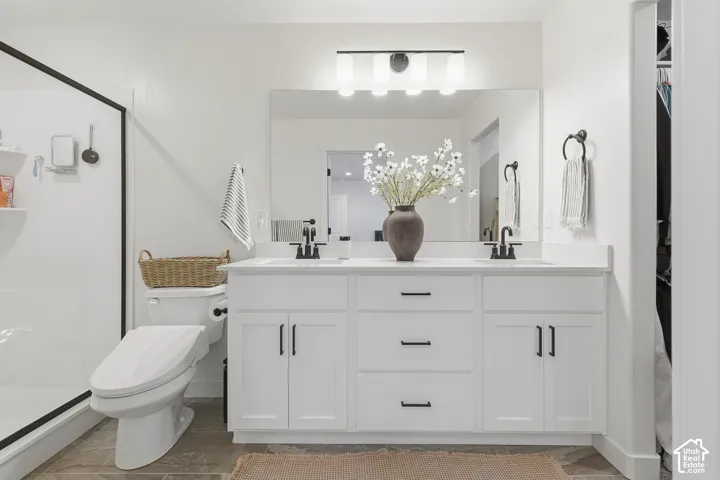 Double vanity featuring white cabinetry, matte black hardware, dual undermount sinks, and a large wall-mounted mirror