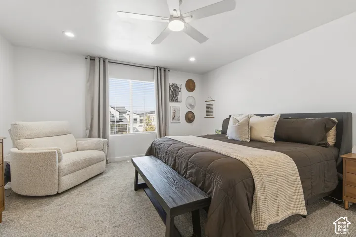 Neutral carpeted flooring, recessed lighting, and a white ceiling fan with integrated lighting