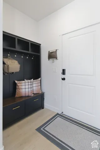 Built-in mudroom cabinetry featuring a dark finish, integrated storage cubbies, brushed brass hardware, and a wood-surface bench