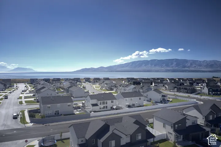 Aerial perspective of residential neighborhood featuring expansive water scenery and distant mountain ranges