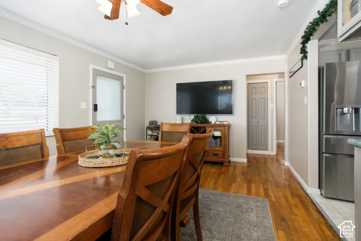 Hardwood flooring, crown molding, ceiling fan, and recessed entry door with frosted glass panel