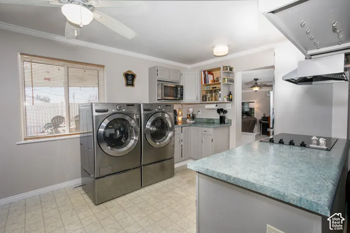 Multipurpose utility space featuring cabinetry, built-in microwave, integrated cooktop, ceiling fan, and window blinds