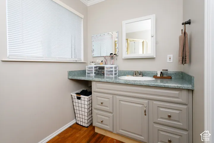 Bathroom vanity featuring a solid surface countertop, integrated oval basin, painted shaker-style cabinetry, and a surface-mounted medicine cabinet