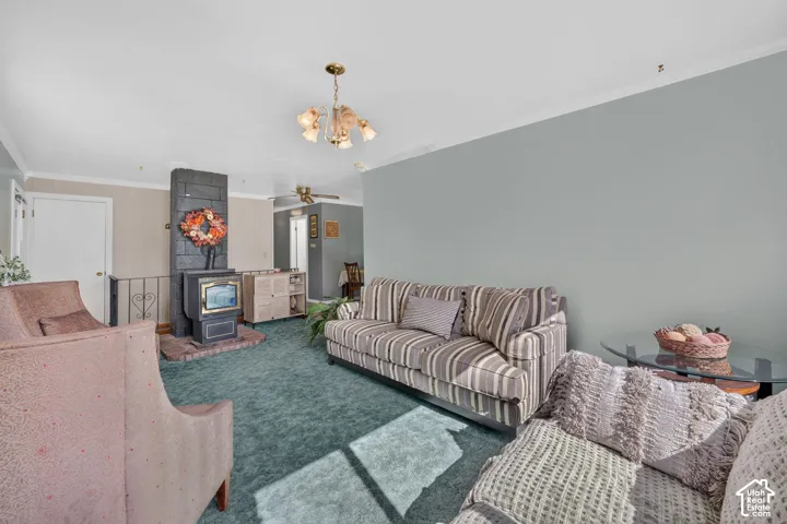 Living area featuring a floor-to-ceiling masonry fireplace, wood-burning stove insert, decorative iron railing, and multi-arm chandelier lighting