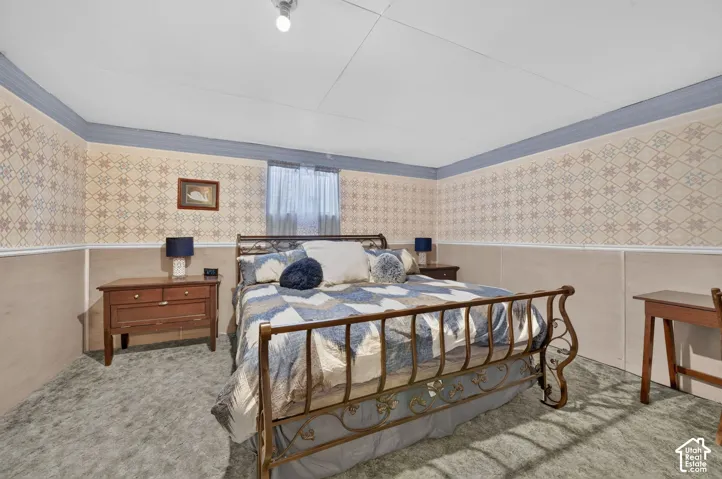 Patterned wallpaper, painted crown molding, chair rail, and wall paneling