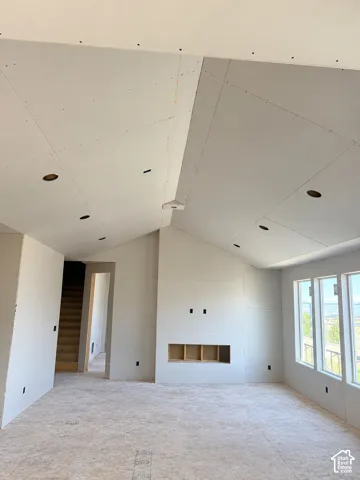 Vaulted ceiling with integrated recessed lighting and a built-in recessed fireplace feature