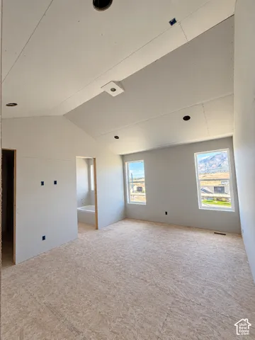 Vaulted ceiling with recessed lighting, two windows with mountain scenery, and subfloor interior