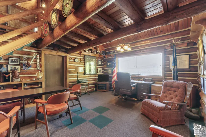Exposed timber log walls and heavy overhead log rafters, vaulted wood-plank ceiling, and built-in wooden shelving units