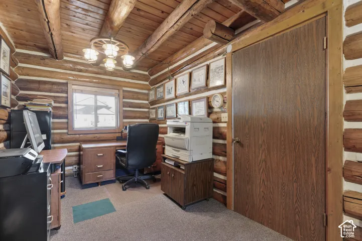 Exposed log walls, beamed ceiling, and decorative wagon wheel light fixture