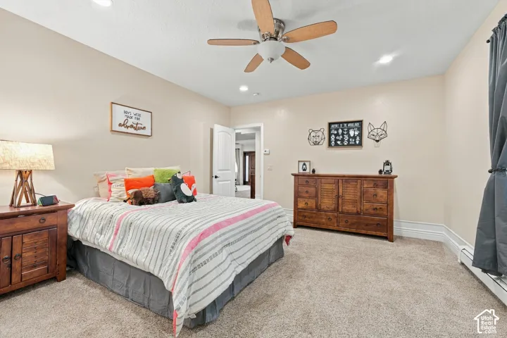 Bedroom featuring neutral wall paint, plush carpeting, a multi-blade ceiling fan, and recessed lighting.