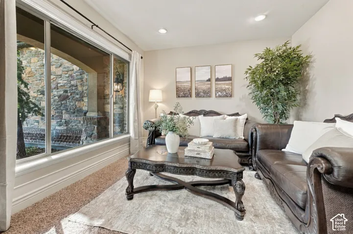 Large window with exterior stone masonry detail, recessed ceiling lighting, and carpeted flooring.