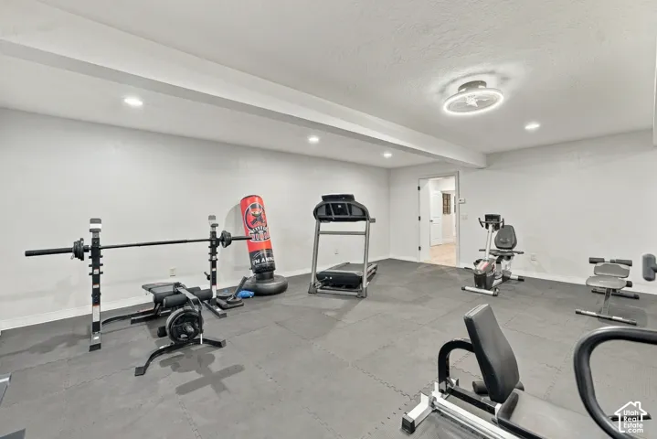Open floor space featuring neutral wall paint, recessed lighting, a contemporary ceiling fan fixture, and interlocking floor tiles.