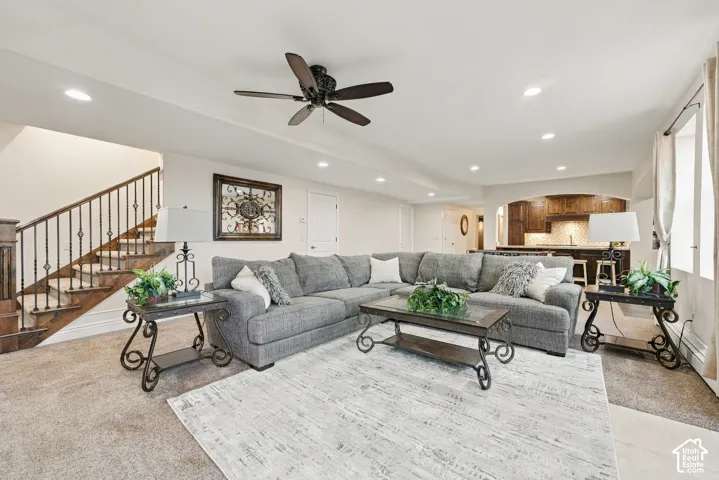Open-concept living space featuring recessed lighting, a ceiling fan, and a staircase with decorative metal balusters.