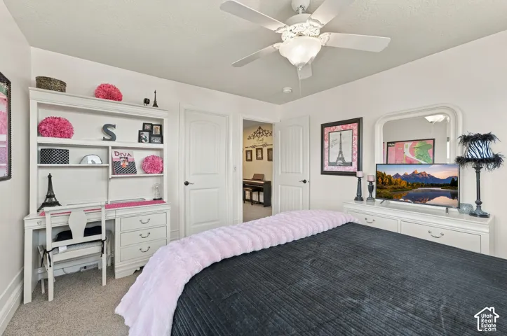 Neutral wall-to-wall carpeting, white panel interior doors, and a ceiling fan with integrated lighting, walk-in closet.
