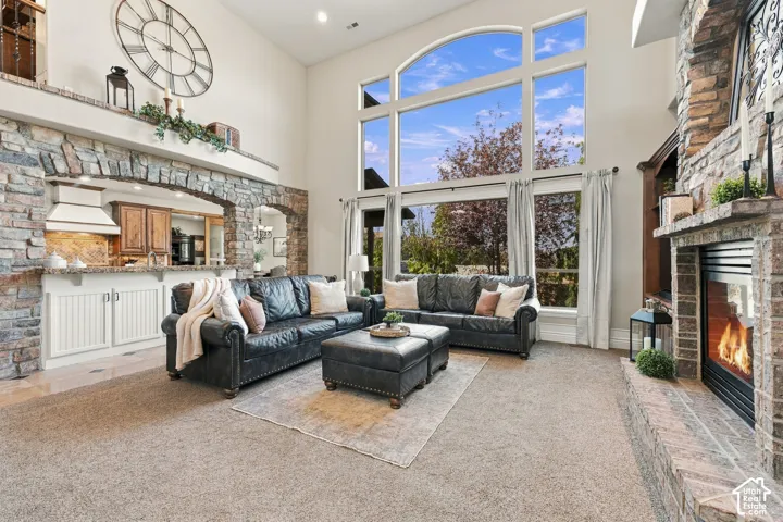 Vaulted ceilings featuring expansive floor-to-ceiling windows, floor-to-ceiling stone-faced fireplace.