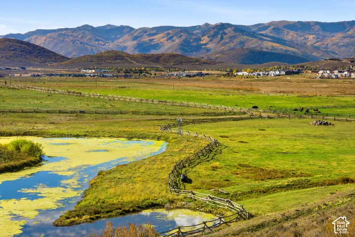 Expansive acreage featuring natural water frontage, mountain scenery, and split-rail perimeter fencing