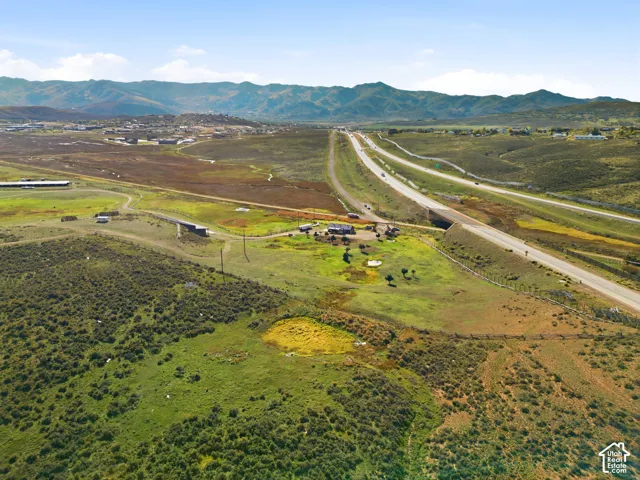Expansive acreage featuring rolling topography, natural pond, and mountain backdrop