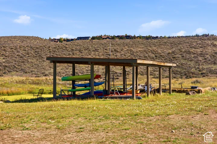 Covered outdoor storage structure featuring a post-and-beam wood frame, flat roof, and open-air design
