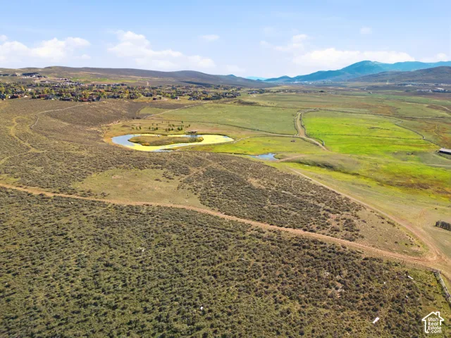 Expansive undeveloped acreage featuring natural terrain, a central pond, and mountain topography