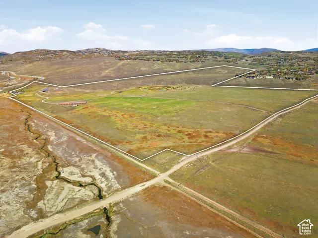 Expansive acreage featuring open meadow terrain, a private pond, and mountain topography