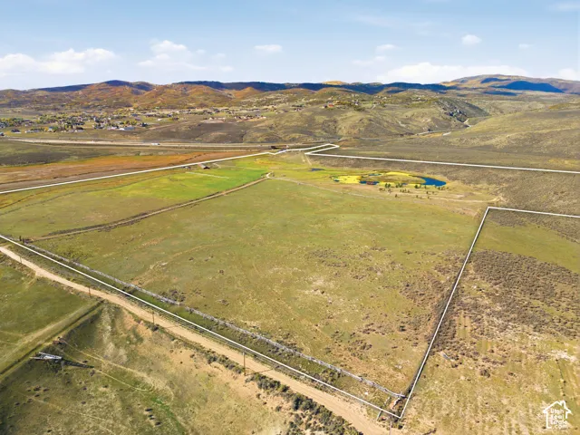 Expansive acreage featuring natural topography, mountain terrain, a private pond, and open meadowland