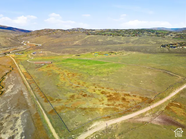 Expansive acreage featuring perimeter fencing, level topography, and mountain backdrops