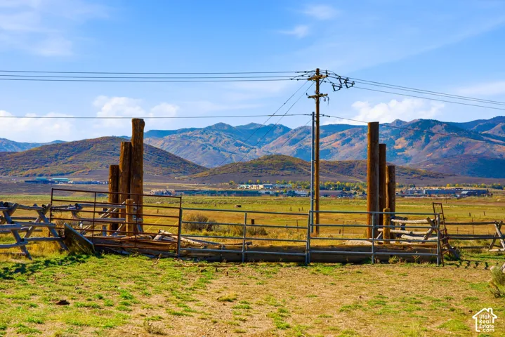Expansive rural acreage featuring mountain scenery, tiered timber post structures, and metal livestock fencing