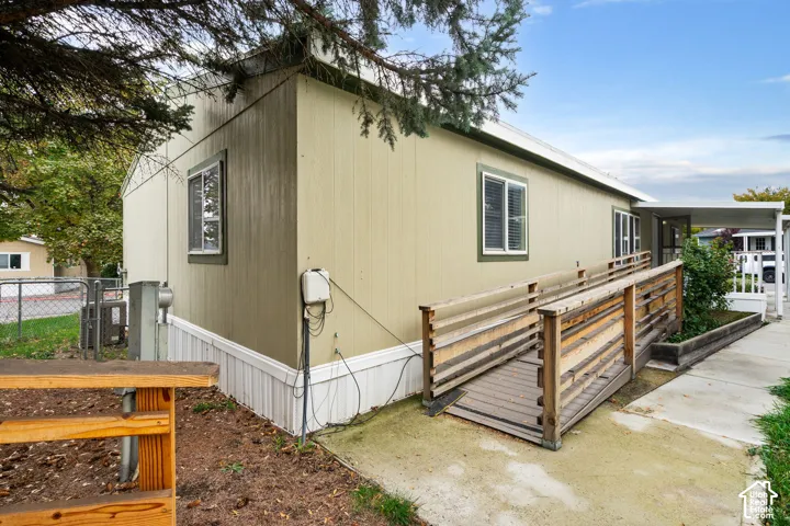 Exterior featuring vertical siding, metal-frame windows, a wood ramp with railings, and a covered entry