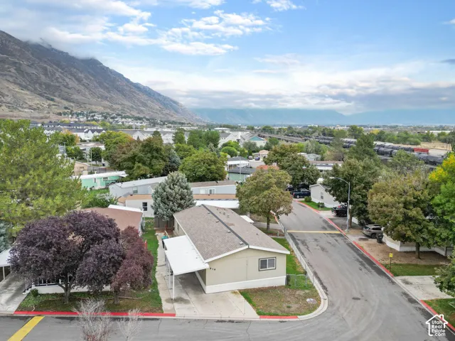 Single-level residence featuring a covered carport, asphalt shingle roof, and exterior siding, situated against a prominent mountain backdrop