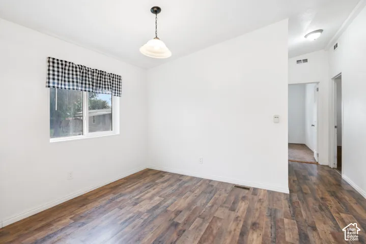 Neutral wall paint, wood-finish flooring, and a single-light pendant fixture