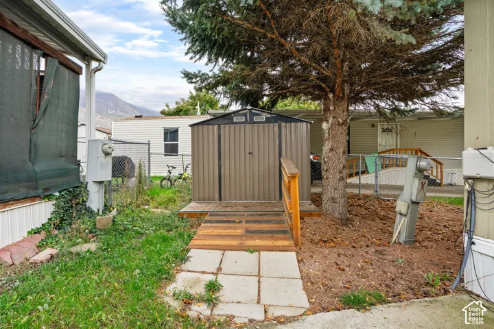 Exterior storage structure with metal siding, featuring a wood-plank ramp and a paved stone pathway