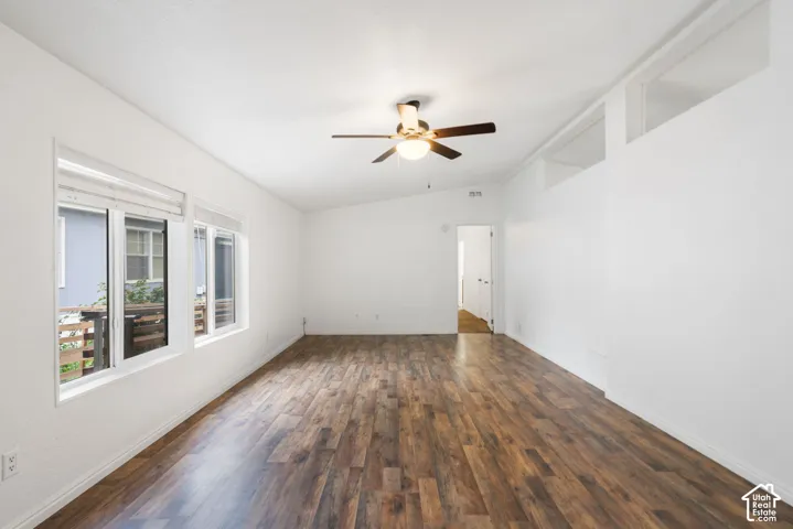 Living area featuring wood-finish flooring, vaulted ceilings with clerestory windows, and a ceiling fan with integrated lighting
