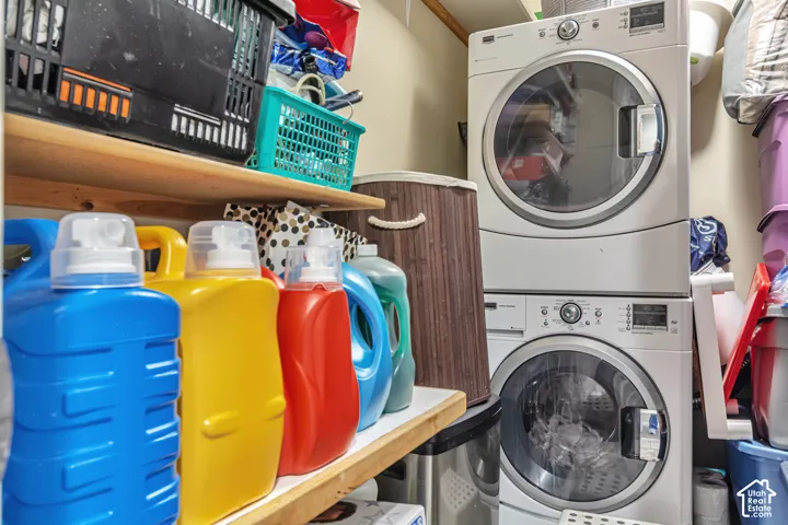 Stacked white front-load washer and dryer unit with built-in wooden shelving