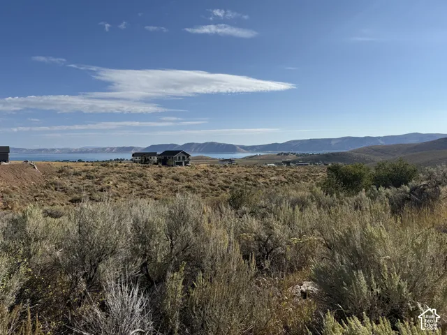 Expansive lot featuring native sagebrush vegetation, rolling terrain, and backdrop of mountain and water scenery