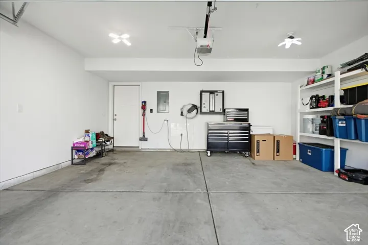 Finished garage interior featuring concrete flooring, ceiling-mounted lighting.