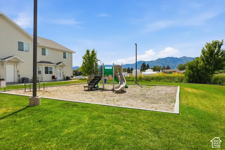 Common area featuring a playground with a slide and climbing structure, set within a manicured lawn