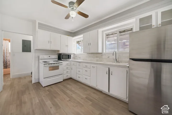 Kitchen featuring wood-finish flooring, white cabinetry, a stainless steel refrigerator, white electric range, and a ceiling fan