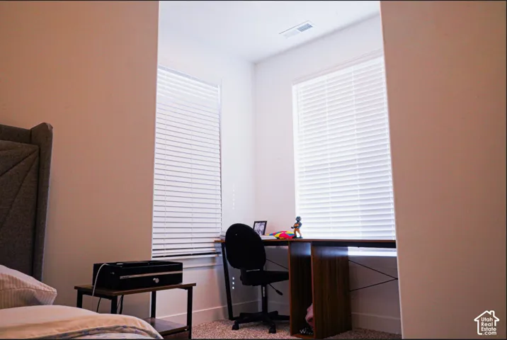 Recessed alcove featuring two large windows with horizontal blinds and wall-to-wall carpeting