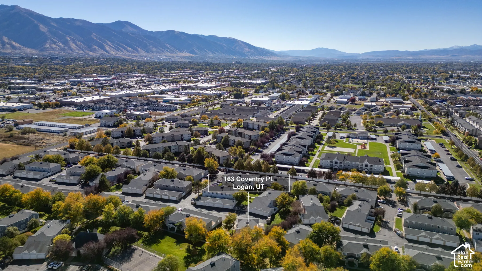 Aerial perspective of the property featuring a suburban setting with mature trees and proximity to mountain range scenery