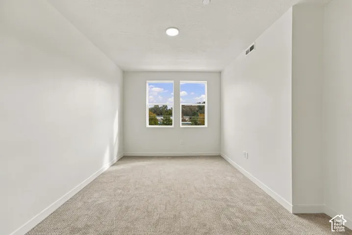 Neutral-toned wall-to-wall carpeting, dual-pane windows, and recessed lighting