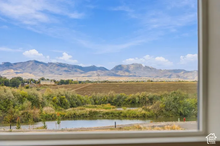 Expansive mountain landscape with a foreground of natural water features and native vegetation