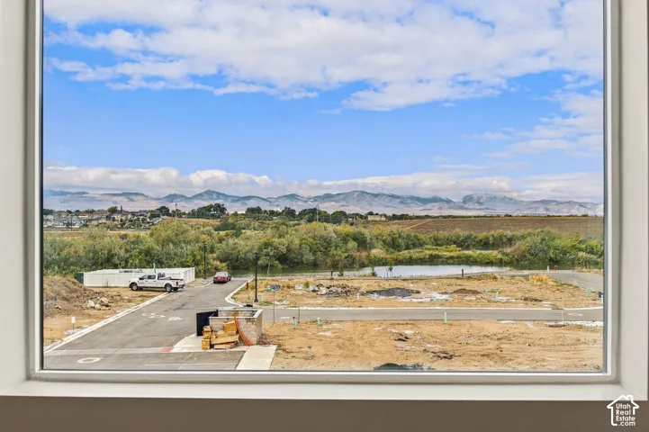 Expansive window frame showcasing mountain scenery, natural landscape, and a water feature