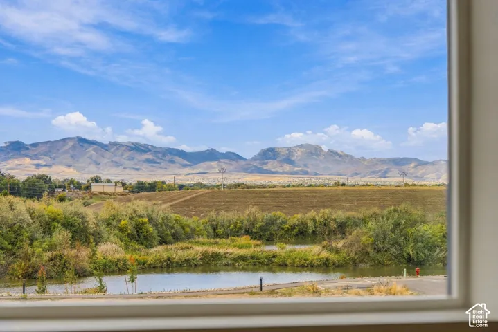 Mountain backdrop featuring a natural pond, native vegetation, and surrounding open terrain
