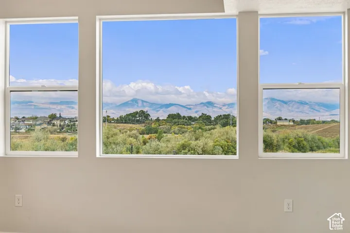 Triple-pane window configuration featuring white frames, large central picture window, and mountain range scenery