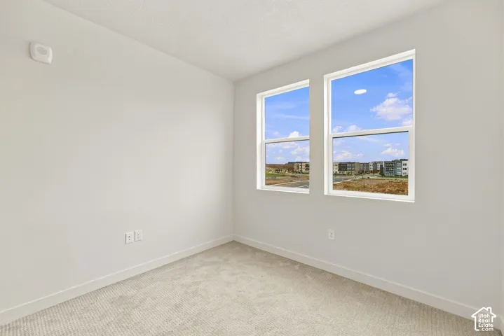 Neutral wall palette, high-pile carpeting, and dual energy-efficient windows providing natural light
