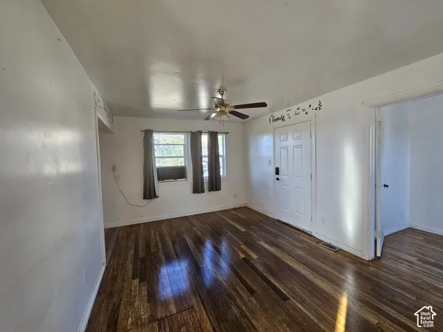 Interior room featuring wood-finish flooring, a ceiling fan with integrated lighting, and multiple windows