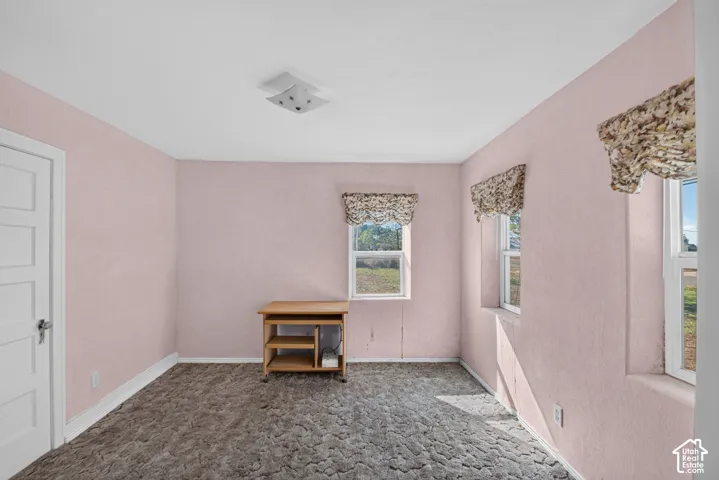 Room featuring textured wall finishes, dual-pane windows, five-panel interior door, and a flush-mount light fixture