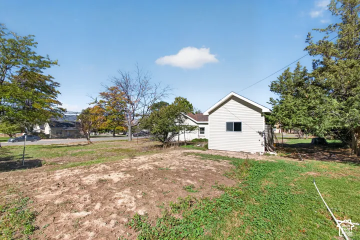 Expansive exterior lot featuring mature trees, a detached structure with siding, and open green space