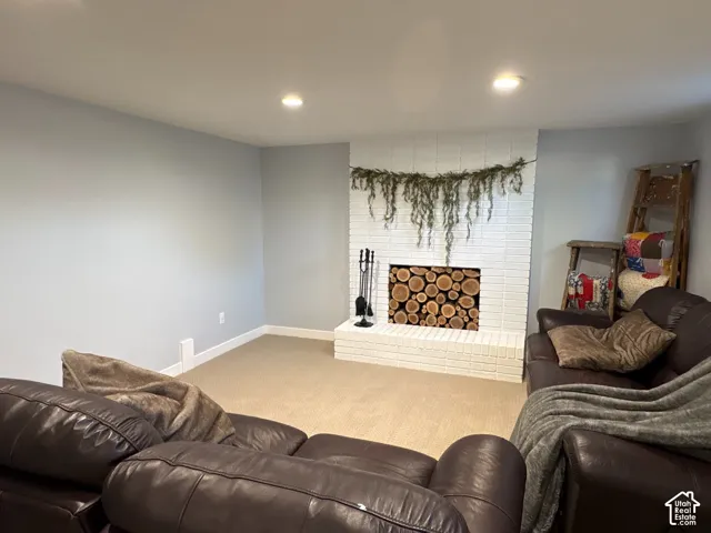 White painted brick fireplace featuring a raised hearth and recessed lighting